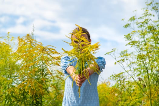 Child in ragweed flowers allergy. Selective focus. Kid.