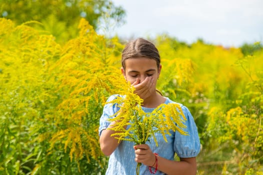 Child in ragweed flowers allergy. Selective focus. Kid.