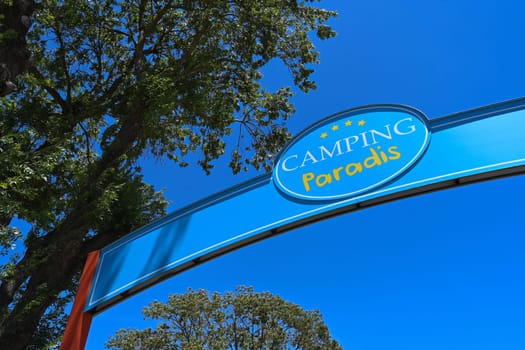 Camping Paradis sign, four stars against a blue sky in Port Grimaud. High quality photo
