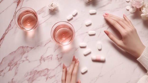 Woman carefully taking daily medication surrounded by water glasses and flowers on a pink marble countertop, emphasizing self care and wellness