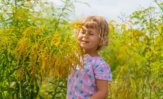 Child in ragweed flowers allergy. Selective focus. Kid.