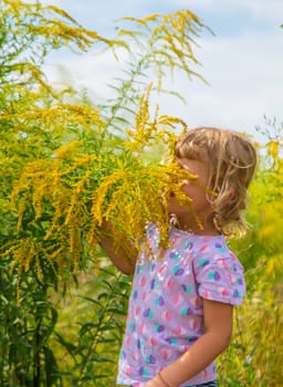 Child in ragweed flowers allergy. Selective focus. Kid.