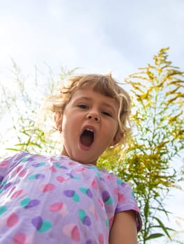 Child in ragweed flowers allergy. Selective focus. Kid.