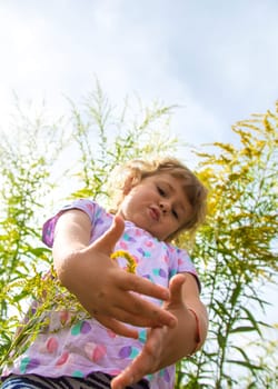 Child in ragweed flowers allergy. Selective focus. Kid.