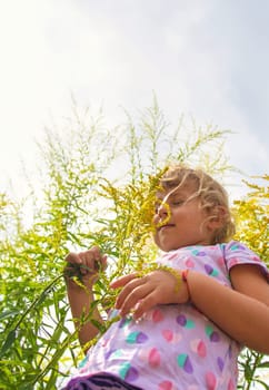 Child in ragweed flowers allergy. Selective focus. Kid.
