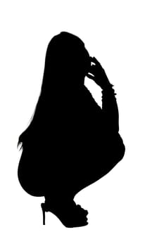 A graceful silhouette of a woman creatively squatting down with her hand thoughtfully resting on her face in a contemplative pose