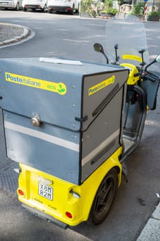Cremona, Lombardy, Italy October 15th 2024 Poste Italiane Yellow three wheeled poste italiane eco friendly delivery scooter parked on the street on a sunny summer day