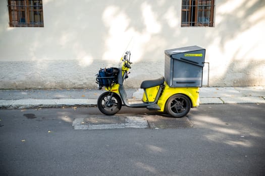 Cremona, Lombardy, Italy October 15th 2024 Poste Italiane Yellow three wheeled motorbike parked on the sidewalk delivering mail and parcels for the postal service in an urban setting