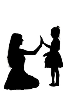A beautiful silhouette of a woman alongside a little girl joyfully giving each other a high five, capturing a moment of happiness and connection
