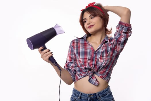 A stylish young woman is playfully using a hair dryer while showcasing a delightful retroinspired look