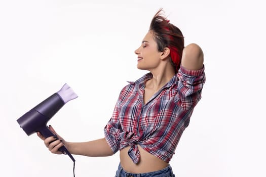 A trendy woman enjoys styling her vibrant hair with a modern hair dryer, showcasing contemporary beauty