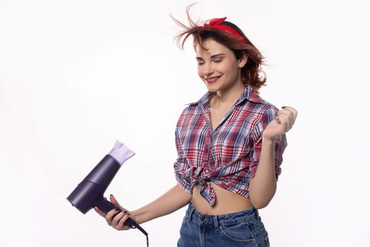 In a cheerful and lively atmosphere, a joyful woman enjoys styling her hair using a dryer with great delight