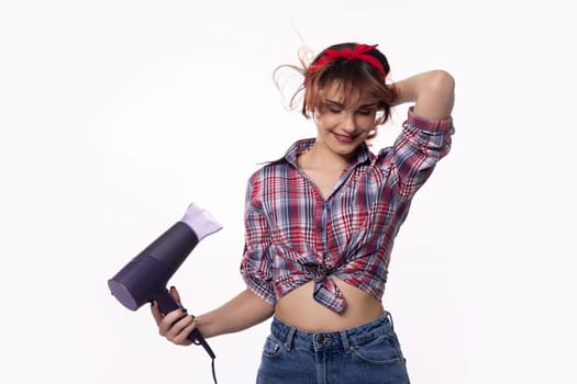 A stylish and fashionable young woman is playfully and joyfully using a hair dryer, showcasing her trendy style