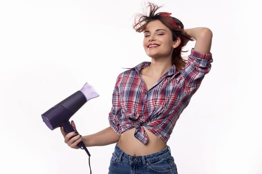 A fashionable woman joyfully styles her hair with a hairdryer, radiating confidence, beauty, and positivity