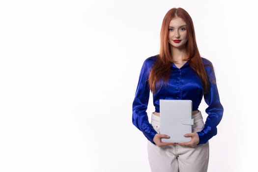 A professional woman in stylish blue attire confidently holds a tablet, ready for business meetings
