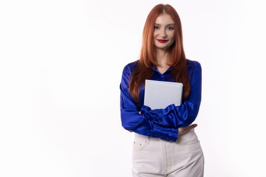 A professional young woman with red hair poses confidently with a clipboard, wearing a stylish blue blouse.