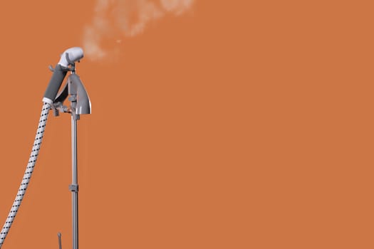 A contemporary steam machine is elegantly releasing steam against a vibrant orange backdrop, showcasing innovation