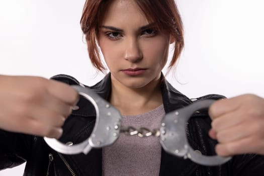 A dramatic and powerful scene shows a young woman breaking free from handcuffs, symbolizing resilience and strength