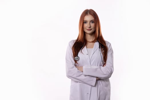 A skilled female doctor stands confidently with her arms crossed in a lab coat and stethoscope around her neck