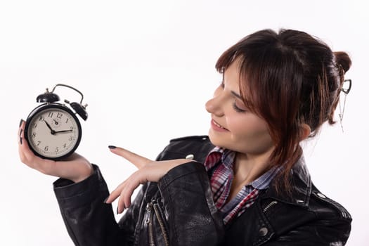 A woman playfully presents an alarm clock, embodying the themes of time management, creativity, and artistic flair