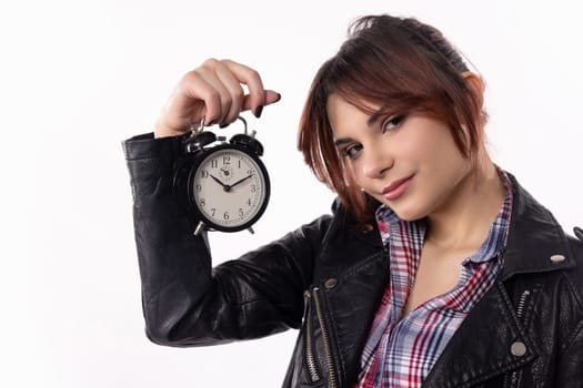 A fashionable woman stands elegantly with a classic alarm clock, showcasing a blend of style and time management