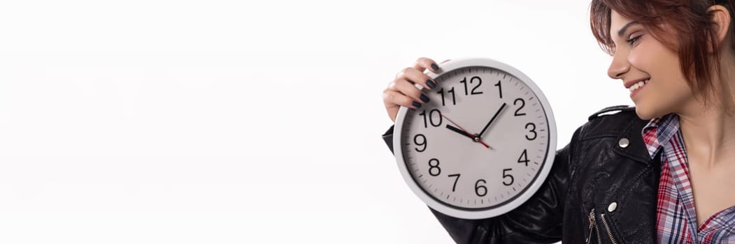 A trendy young woman smiles while holding a stylish clock, symbolizing time management and modern fashion