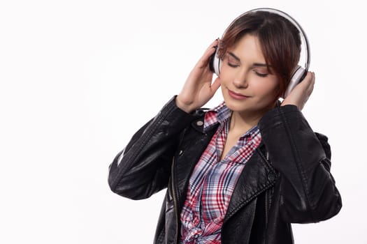 A stylish young woman wearing headphones, deeply immersed in music, effortlessly exuding contemporary modern vibes