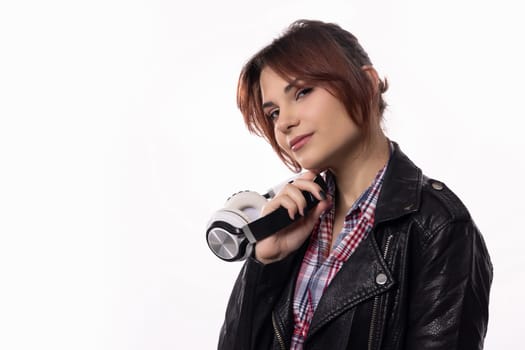 A chic and stylish young woman confidently poses outdoors while holding a flashlight in her leather jacket