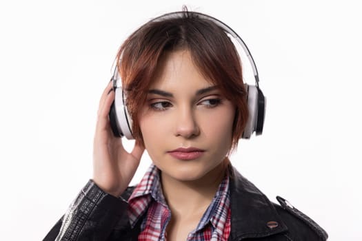 A stylish young woman enjoys her music with sleek headphones, showcasing a vibrant modern lifestyle
