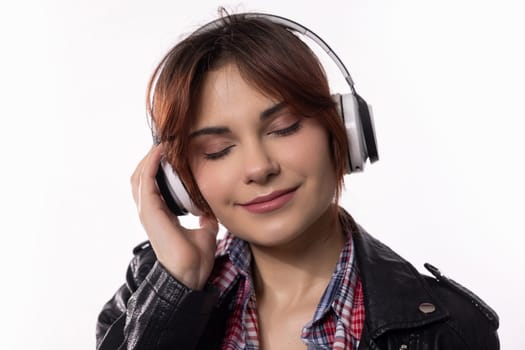 A vibrant young woman is immersed in her music experience, enjoying it through her stylish headphones