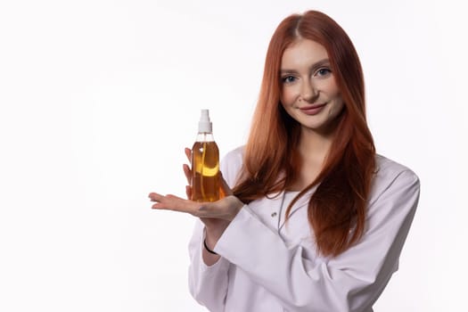 A professional woman elegantly displays a hair oil bottle, highlighting the significance of beauty and selfcare