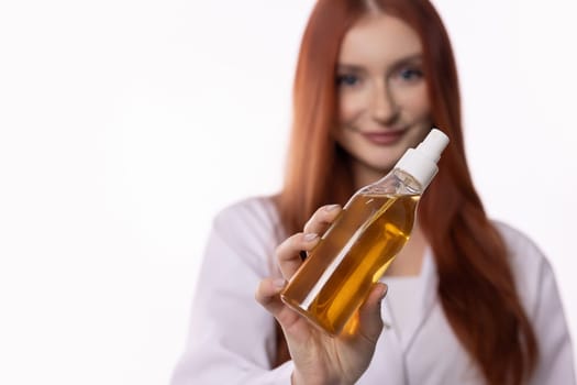 A skilled professional showcases a luxury skincare oil bottle, highlighting its beauty and wellness benefits