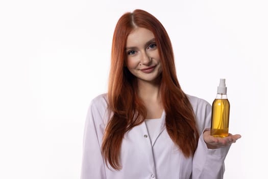 A smiling woman proudly displays a bottle of golden hair oil, promoting effective hair care routines