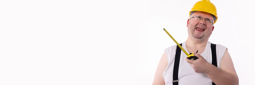 A cheerful construction worker wearing a bright hard hat is proudly holding a measuring tape with a playful demeanor