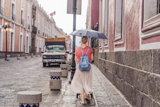 Female tourist walking through the colorful colonial streets of Puebla, Mexico. Travel, cultural exploration, and vibrant architecture concept.