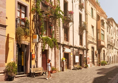 Female tourist walking through the streets of Bosa. Sardinia, Italy