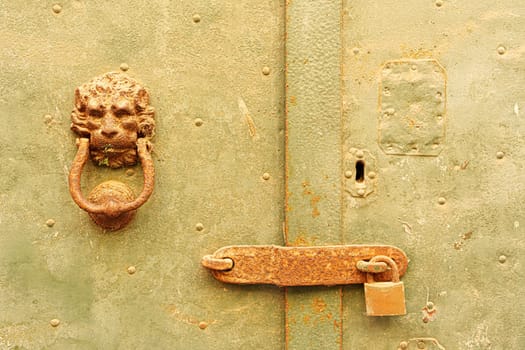 Detail of a knocker and a bolt on an old door. Bosa, Sardinia, Italy