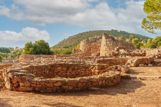 Traveler visiting the Palmavera Nuragic site, near Alghero. Sardinia, Italy