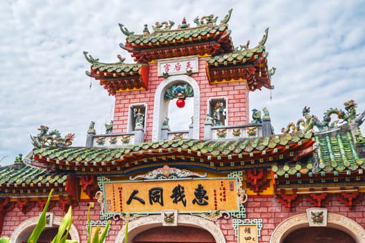 Beautiful ancient red Asian gate to the Buddhist pagoda in old town in Hoi An in Vietnam in Asia