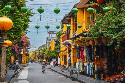 Street in old town in Hoi An city with traditional ancient yellow houses and buildings in summer in day. Hoi An, Vietnam - September 12, 2024