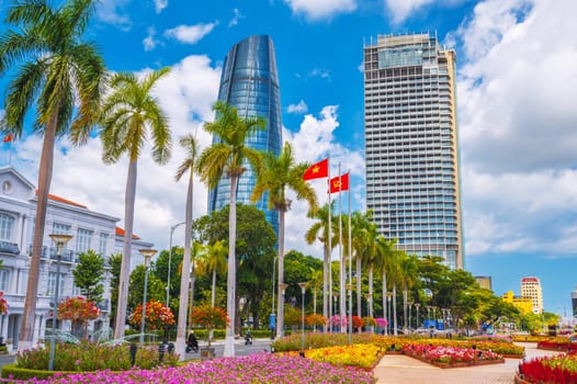 Palm trees and skyscrapers on the Han River embankment in Da Nang in Vietnam in summer