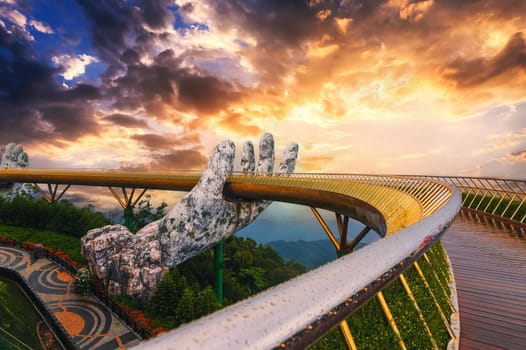 Golden Bridge or Hand of Gods bridge at Sun World Ba Na Hills amusement Park in Da Nang in Vietnam on the mountain at sunrise in summer