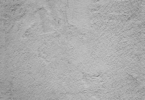 Fragment of an old concrete wall with worn gray plaster.