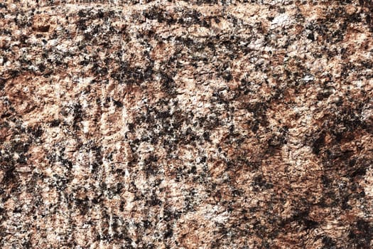 Brown stone wall close up. Wall surface made of granite.