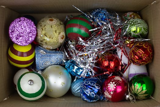 Cardboard box with New Year toys inside, top view. Christmas toys in box for decorating festive tree for New Year, storing New Year attributes at home
