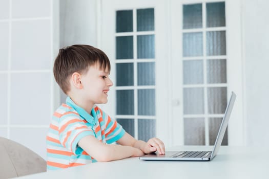 Schoolboy At Table With Laptop