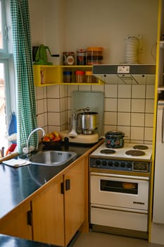 A small, cozy kitchen featuring retro design elements, vintage appliances, and bright yellow accents. Ideal for nostalgic spaces or retro decor inspiration