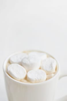 A cup of hot chocolate topped with marshmallows, offering a warm and cozy treat for the winter season.