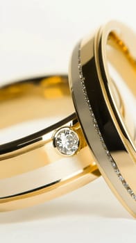 Two simple gold wedding rings are laying on white cloth, ready for the couple to exchange during their wedding ceremony