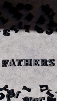 Lettering father in black letters on grey background on father's day close-up